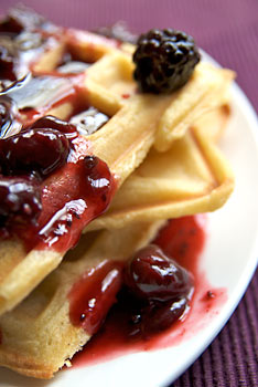 Polenta waffles with mixed berry sauce