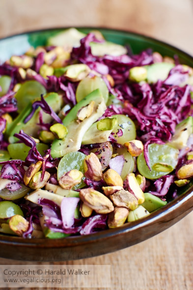 Red cabbage salad with avocado, grapes, pistachios  and  a poppy seed dressing.